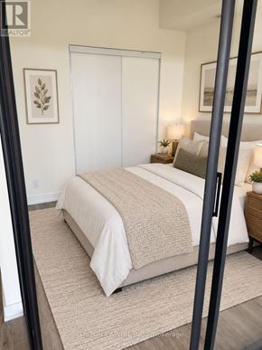 Welland (Broadway) condo for rent - A bedroom with a large bed and a mirror on the wall.