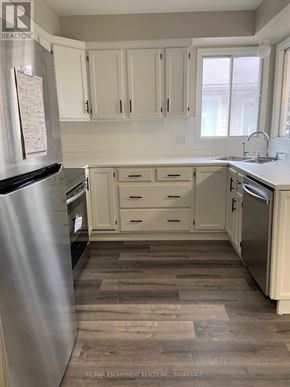 Welland (N. Welland) apartment for rent - A kitchen with white cabinets and a stainless steel refrigerator.