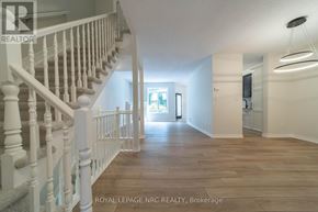 Niagara Falls (Morrison) townhouse for rent - A spacious hallway with a staircase on the left and a doorway leading to another room on the right.