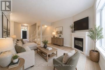 Niagara Falls (Morrison) townhouse for rent - A living room with a fireplace and a television on the wall.