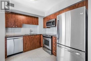 Toronto (Islington-City Centre West) condo for rent - A kitchen with wooden cabinets and stainless steel appliances.