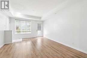 Toronto (Long Branch) townhouse for rent - A room with wooden flooring and white walls, with a window and a door visible.