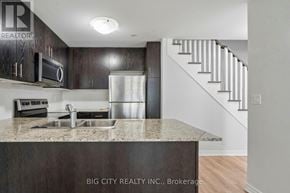 Toronto (Long Branch) townhouse for rent - A kitchen with a sink and a refrigerator.