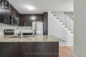 Toronto (Long Branch) townhouse for rent - A kitchen with a sink and a refrigerator.