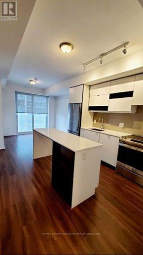 Mississauga (City Centre) condo for rent - A modern kitchen with white cabinets and a wooden floor.