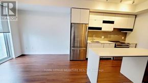 Mississauga (City Centre) condo for rent - A modern kitchen with white cabinets and a wooden floor.