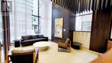 Mississauga (City Centre) condo for rent - A living room with a couch, chair, and a painting on the wall.