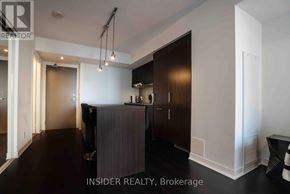 Toronto (Waterfront Communities) condo for rent - A modern kitchen with dark wood cabinets and a white countertop.