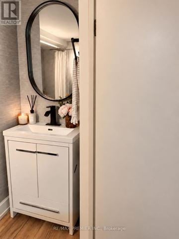 Oakville (Wo West) apartment for rent - A white bathroom vanity with a round mirror above it.
