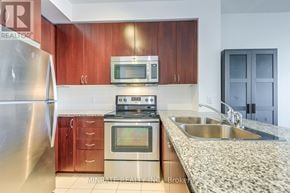 Mississauga (City Centre) condo for rent - A kitchen with a stainless steel refrigerator, a microwave, a stove, and a sink.