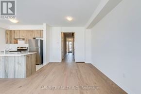 Hamilton (Mount Hope) townhouse for rent - A spacious kitchen with wooden cabinets and a refrigerator.
