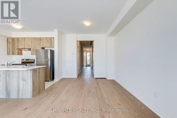 Hamilton (Mount Hope) townhouse for rent - A spacious kitchen with wooden cabinets and a refrigerator.