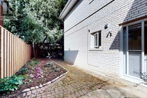 Toronto (Westminster-Branson) apartment for rent - A brick pathway leads to a grey house with a small garden.