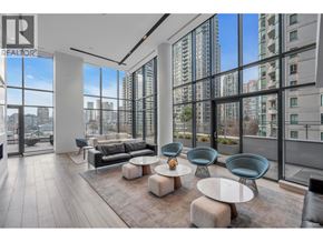 Vancouver apartment for rent - A modern living room with a view of the cityscape outside the large windows.