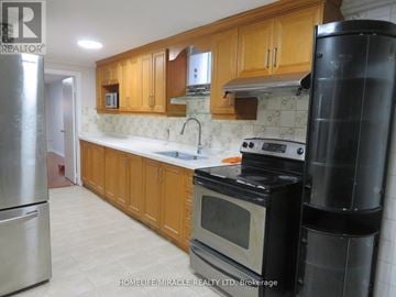 Richmond Hill (Devonsleigh) apartment for rent - A kitchen with wooden cabinets and a black refrigerator.