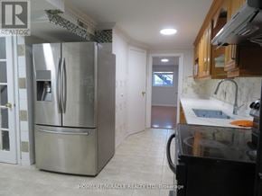 Richmond Hill (Devonsleigh) apartment for rent - A kitchen with a stainless steel refrigerator and black countertop.