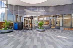 Mississauga (Hurontario) condo for rent - The lobby of a building with a large glass wall and a circular planter.