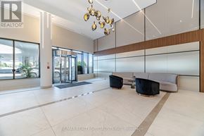 Mississauga (Hurontario) condo for rent - A modern office lobby with a glass wall and a black and white rug.