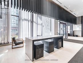 Mississauga (City Centre) condo for rent - A modern office lobby with a reception desk and a chair.