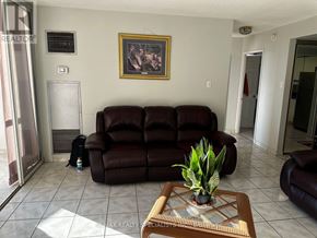 Toronto (West Humber-Clairville) condo for rent - A living room with a brown leather couch and a painting on the wall.