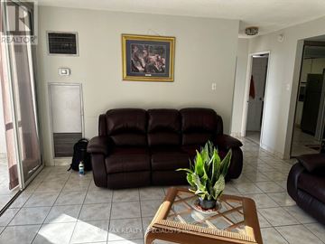 Toronto (West Humber-Clairville) condo for rent - A living room with a brown leather couch and a painting on the wall.