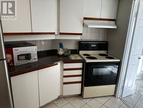 Toronto (West Humber-Clairville) condo for rent - A kitchen with white cabinets and a black stove top oven.