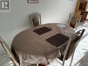Toronto (West Humber-Clairville) condo for rent - A dining table with chairs and a tablecloth is set up in a room.