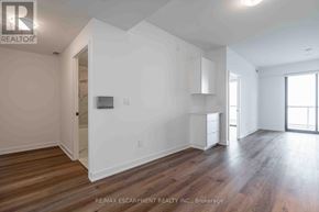 Burlington (Brant) condo for rent - A room with wooden floors and white walls, with a door on the left and a window on the right.