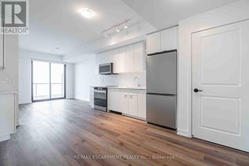 Burlington (Brant) condo for rent - A kitchen with white cabinets and a refrigerator.