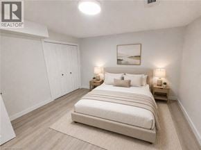 Hamilton apartment for rent - A bedroom with a large bed, two nightstands, and a painting on the wall.