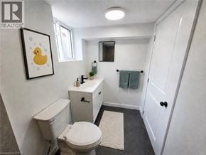 Hamilton apartment for rent - A bathroom with a toilet, sink, and mirror.