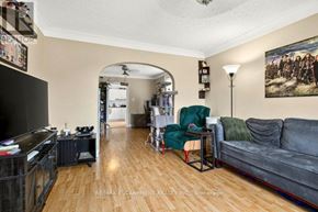 Thorold (Thorold Downtown) apartment for rent - A living room with a grey couch, a green chair, and a painting on the wall.