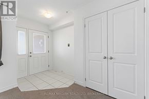 Thorold (Confederation Heights) townhouse for rent - A white room with a carpeted floor and a brokerage sign.