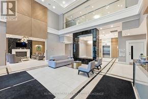 Niagara Falls (Hospital) condo for rent - A spacious living room with a black and white rug, a white sofa, and a television.