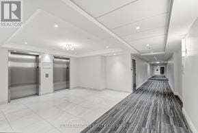 Niagara Falls (Hospital) condo for rent - A long hallway with a carpeted floor and two elevators.