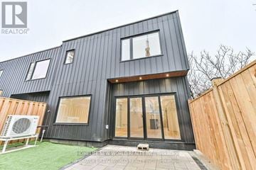 Toronto (Dufferin Grove) apartment for rent - A modern black house with a wooden fence in front.