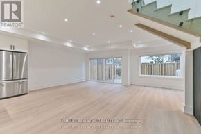 Toronto (Dufferin Grove) apartment for rent - A spacious, empty room with a stainless steel refrigerator on the left side.