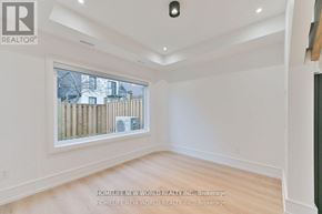 Toronto (Dufferin Grove) apartment for rent - A room with white walls and wooden flooring, with a window showing a view of a fence and buildings outside.