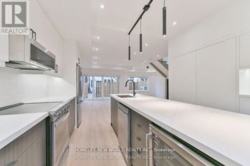 Toronto (Dufferin Grove) apartment for rent - A modern kitchen with white cabinets and a wooden floor.