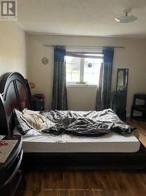 Brampton (Sandringham-Wellington) townhouse for rent - A bedroom with a bed, a chair, and a window with curtains.