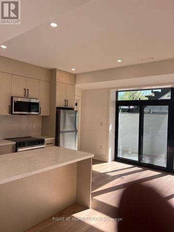 Toronto (Islington-City Centre West) apartment for rent - A modern kitchen with a white countertop and a microwave above it.