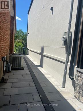 Toronto (Islington-City Centre West) apartment for rent - A sidewalk runs between a brick building and a concrete building.
