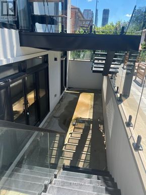 Toronto (Islington-City Centre West) apartment for rent - A glass staircase with a metal railing leads to a balcony.