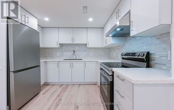 Brampton (Brampton South) apartment for rent - A modern kitchen with white cabinets and a stainless steel refrigerator.