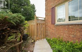 Brampton (Brampton South) apartment for rent - A wooden fence and gate in front of a brick building.