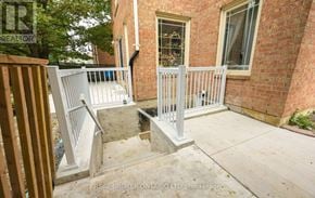 Brampton (Brampton South) apartment for rent - A brick house with a white railing and steps leading to a door.