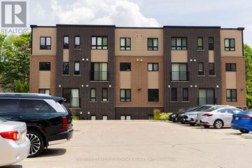Kitchener townhouse for rent - A building with a car parked in front of it.