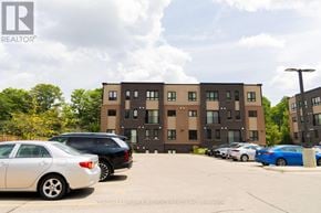 Kitchener townhouse for rent - A parking lot with cars and a building in the background.