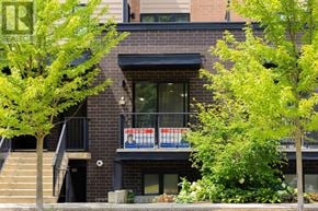 Kitchener townhouse for rent - A tree in front of a brick building.