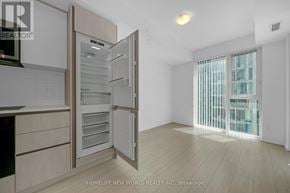 Toronto (Waterfront Communities) condo for rent - A modern kitchen with a refrigerator and cabinets.